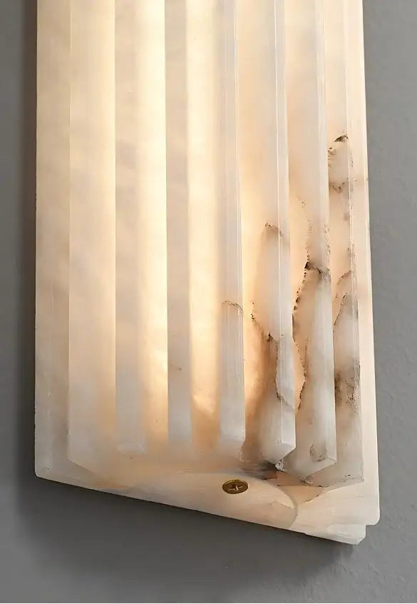 Applique murale design en marbre et laiton, format vertical, diffusant une lumière douce et homogène, idéale pour une salle de bain moderne ou un intérieur contemporain