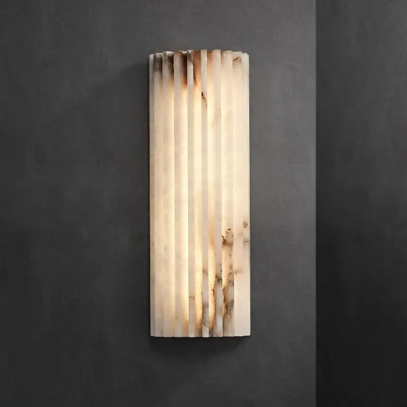 Applique murale design en marbre et laiton, format vertical, diffusant une lumière douce et homogène, idéale pour une salle de bain moderne ou un intérieur contemporain