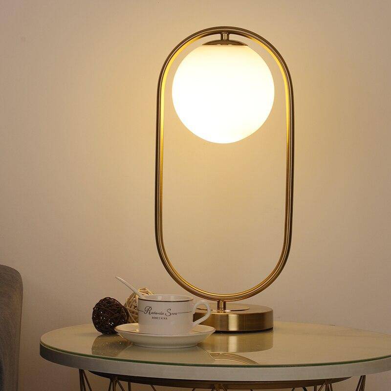Lampe à poser moderne dorée avec globe lumineux