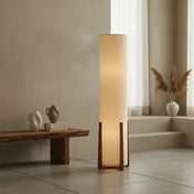 Wabi-sabi floor lamp with wooden base and cylindrical fabric shade, placed in a minimalist interior with natural tones