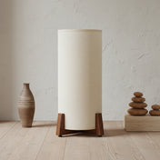 small Wabi-sabi floor lamp with wooden base and cylindrical fabric shade, placed in a minimalist interior with natural tones